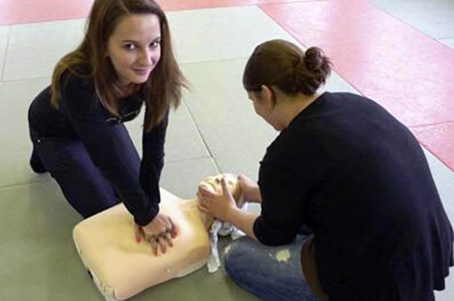 Zwei Frauen üben Reanimation an einer Puppe